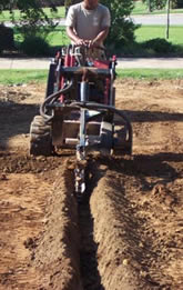 A Technician Digging Out A Trench For the Underground Sprinkler system Scottsale irrigation technician digs a trench